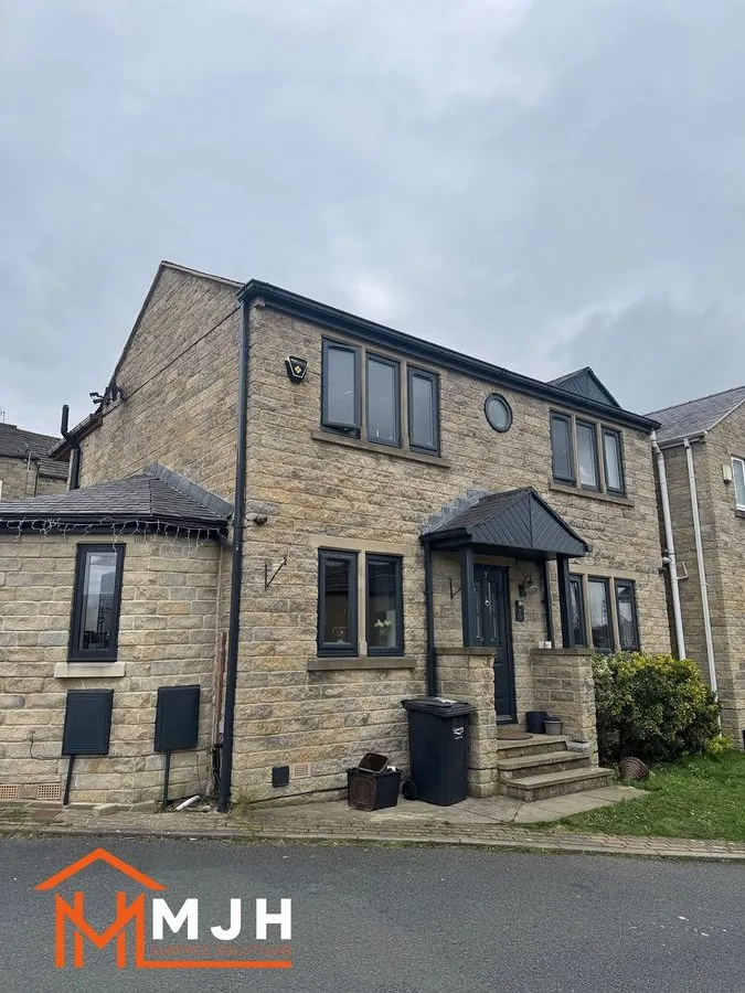 The same house with every frame, the door and the porch canopy sprayed anthracite grey