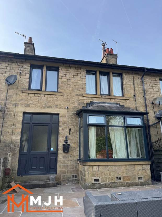 The same house after spraying, with the bay window in anthracite grey